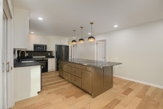 kitchen with white cabinetry, a center island, sink, stainless steel appliances, and decorative light fixtures