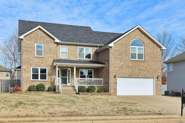 view of front of property featuring a front yard, a porch, and a garage