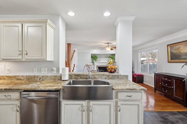 kitchen featuring light stone countertops, ceiling fan, crown molding, sink, and dishwasher