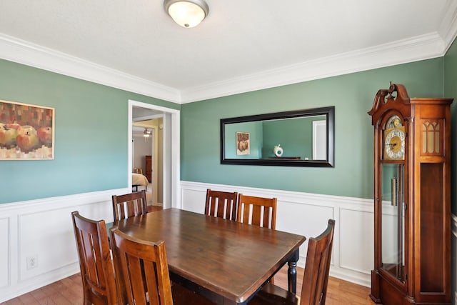 dining area with hardwood / wood-style flooring and crown molding