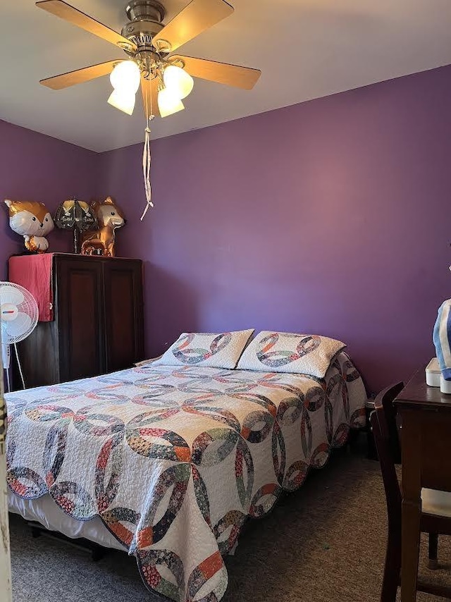 bedroom with ceiling fan and dark colored carpet