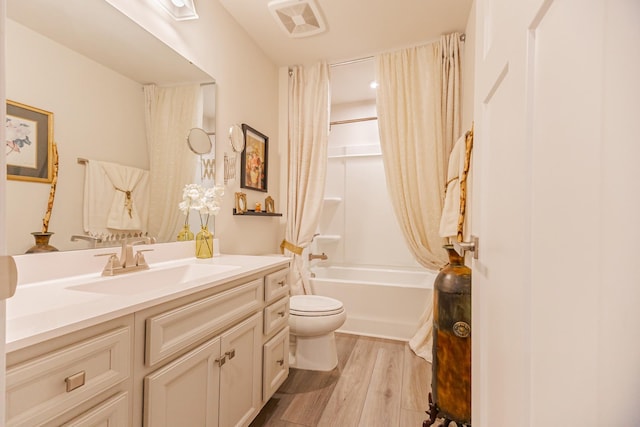 full bathroom with wood-type flooring, vanity, shower / tub combo with curtain, and toilet