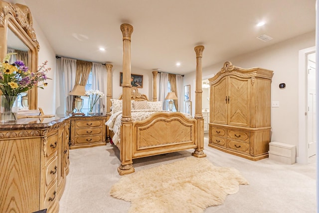 bedroom with ornate columns and light carpet