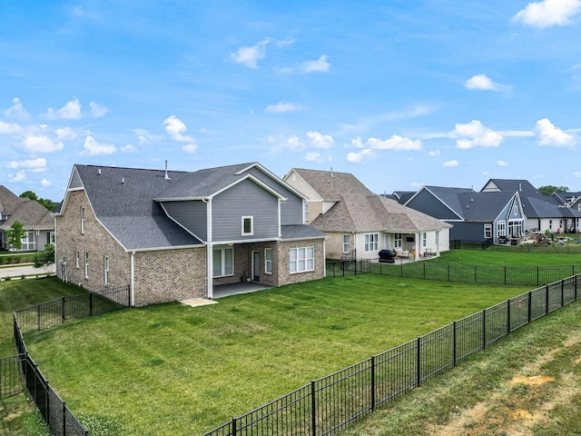 rear view of property with a yard and a patio