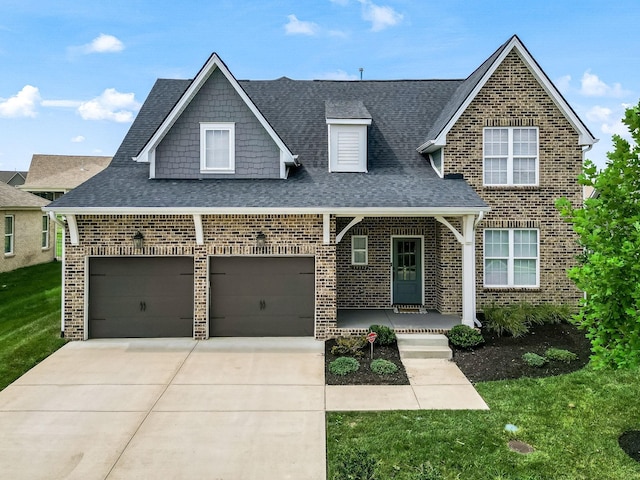 view of front of house with a garage, covered porch, and a front lawn