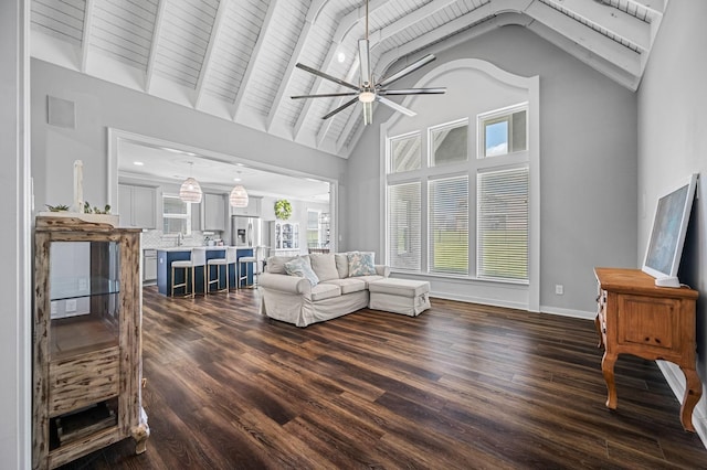 living room with ceiling fan, beam ceiling, dark hardwood / wood-style flooring, and high vaulted ceiling