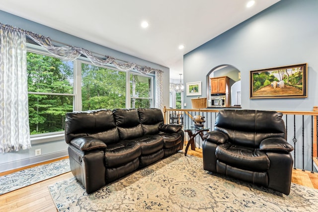 living room featuring a chandelier, hardwood / wood-style floors, and lofted ceiling