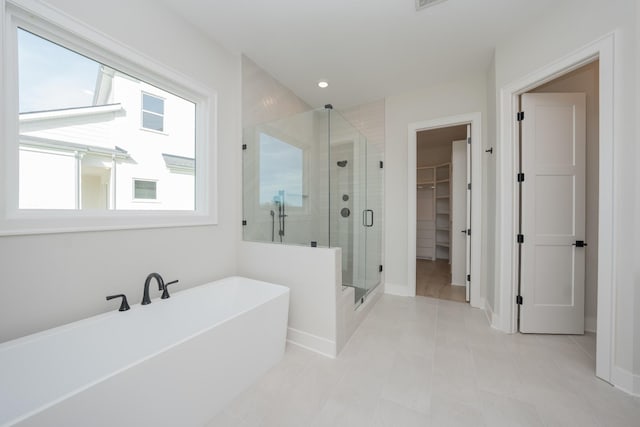 bathroom with tile patterned floors and shower with separate bathtub