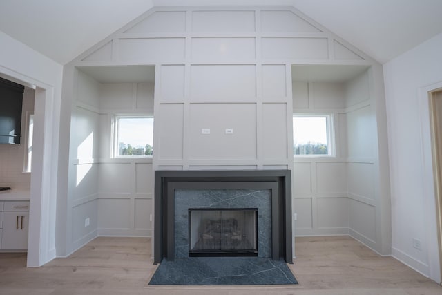 interior details with a tile fireplace and wood-type flooring