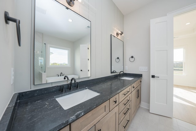 bathroom featuring tile patterned flooring, vanity, lofted ceiling, and a washtub