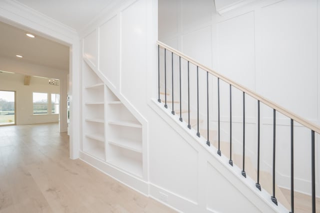 stairway with hardwood / wood-style flooring and built in features