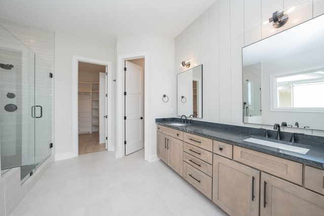 bathroom with tile patterned flooring, vanity, and a shower with door