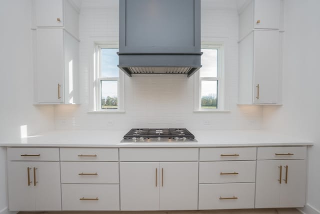 kitchen featuring white cabinets, tasteful backsplash, and stainless steel gas stovetop