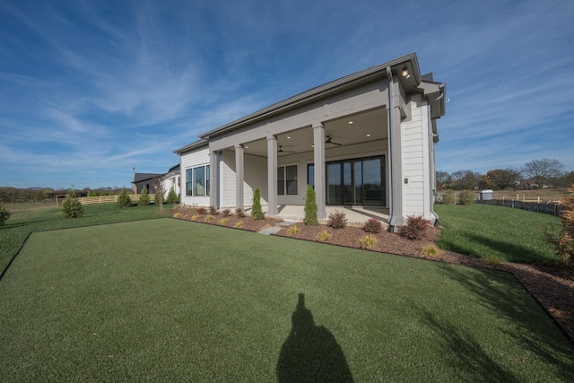 rear view of house with a lawn, ceiling fan, and a patio area