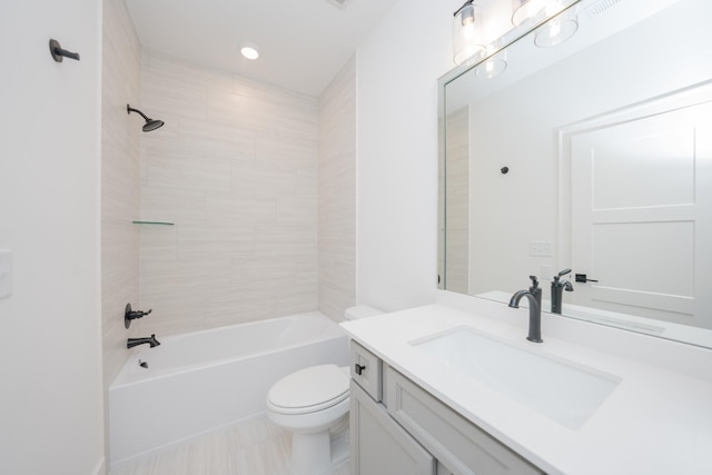 full bathroom with vanity, tiled shower / bath combo, and toilet