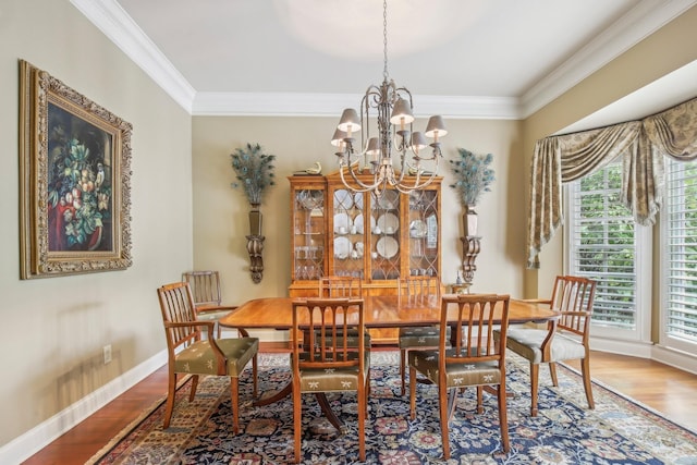 dining space with a chandelier, wood-type flooring, and ornamental molding