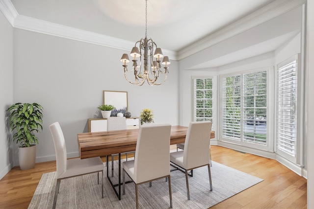 dining space with light wood-type flooring and an inviting chandelier