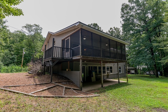 back of house with a yard, a patio area, and a sunroom