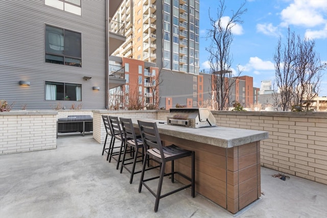 view of patio / terrace with a grill, an outdoor bar, and exterior kitchen