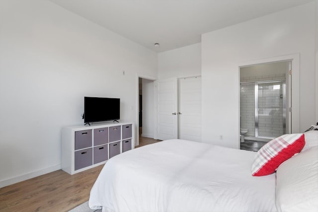 bedroom featuring dark hardwood / wood-style flooring and connected bathroom