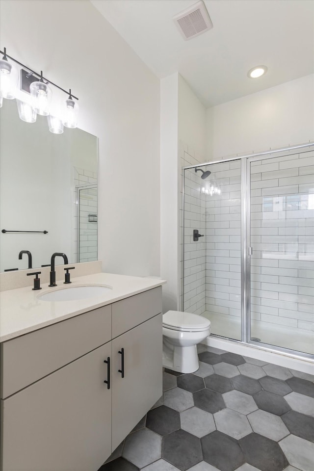 bathroom with vanity, an enclosed shower, and toilet