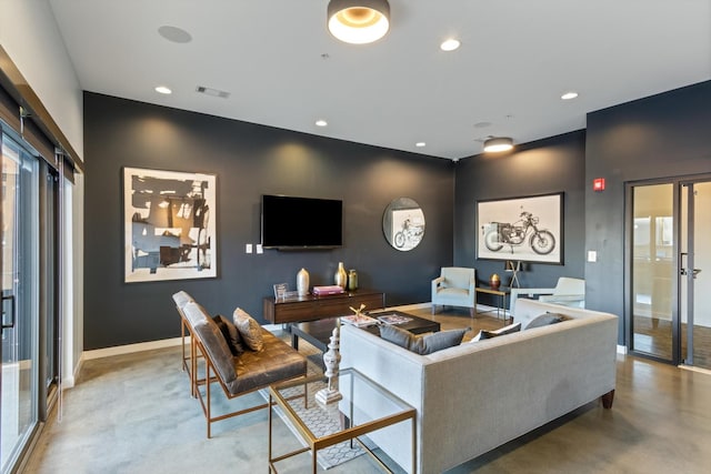 living room featuring plenty of natural light and concrete flooring