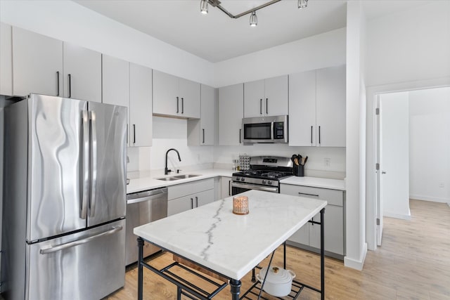 kitchen with a center island, sink, light hardwood / wood-style flooring, a kitchen bar, and stainless steel appliances