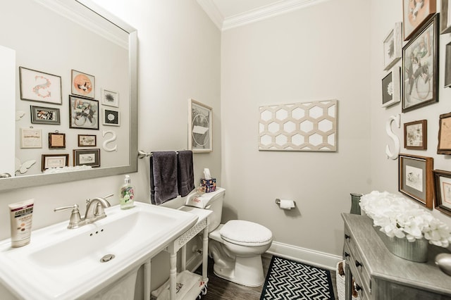 bathroom featuring hardwood / wood-style floors, toilet, ornamental molding, and sink