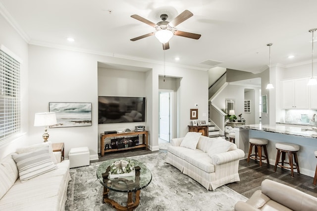 living room featuring dark hardwood / wood-style floors, ceiling fan, and ornamental molding