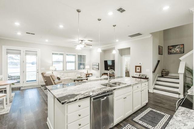 kitchen featuring light stone countertops, white cabinets, sink, decorative light fixtures, and dishwasher