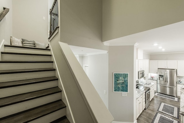 staircase with hardwood / wood-style flooring and ornamental molding