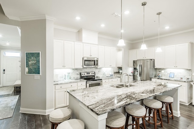 kitchen featuring white cabinetry, a center island with sink, hanging light fixtures, and appliances with stainless steel finishes