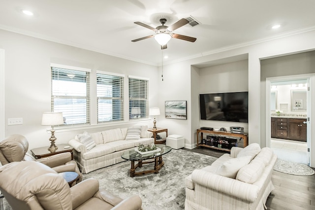 living room with light wood-type flooring, ceiling fan, and ornamental molding