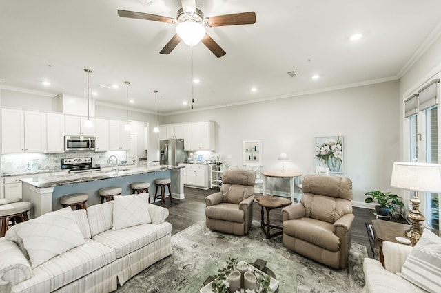 living room with hardwood / wood-style floors, ceiling fan, ornamental molding, and sink