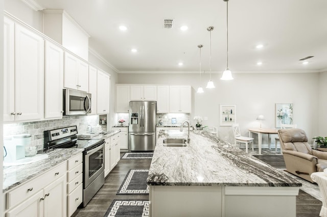 kitchen with stainless steel appliances, white cabinetry, a spacious island, and sink