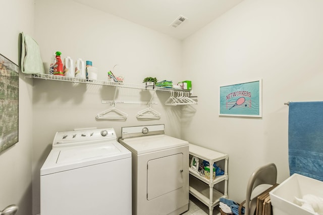 washroom featuring light tile patterned floors, washer and clothes dryer, and sink