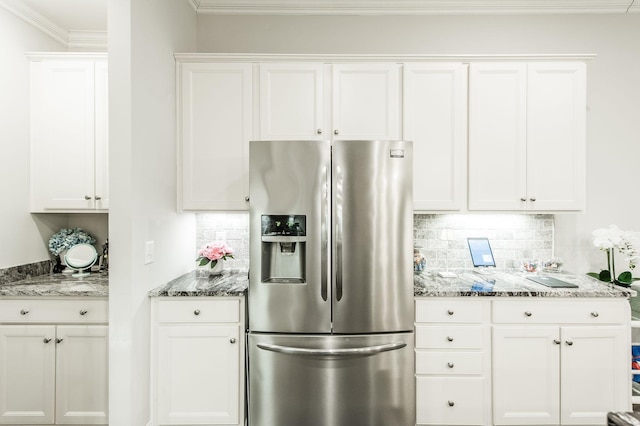 kitchen with white cabinets, stone countertops, stainless steel refrigerator with ice dispenser, and tasteful backsplash