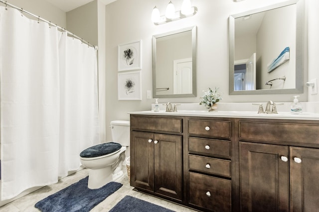 bathroom featuring tile patterned flooring, vanity, and toilet