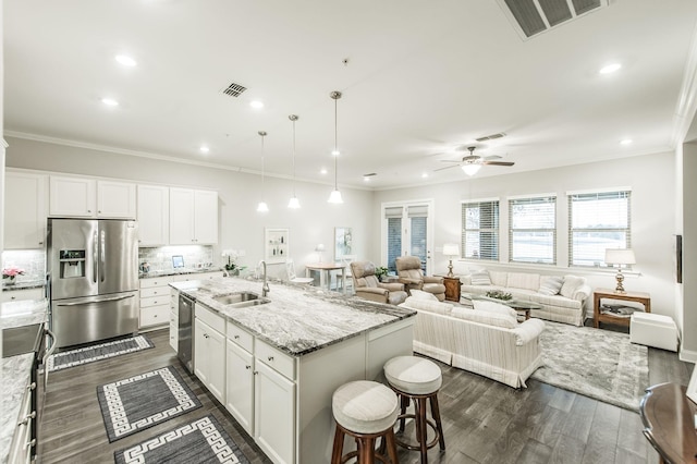 kitchen with a center island with sink, sink, white cabinetry, and stainless steel appliances