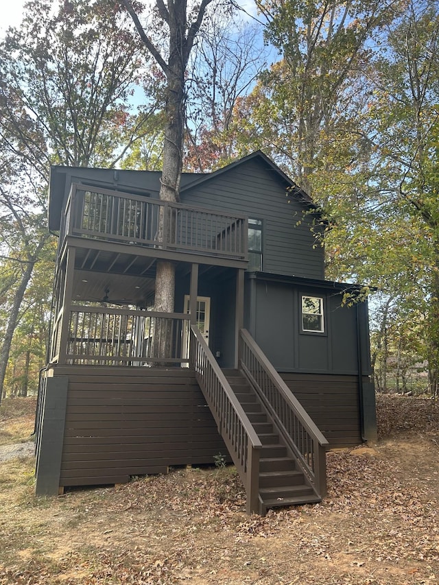 rear view of property featuring a deck and stairway