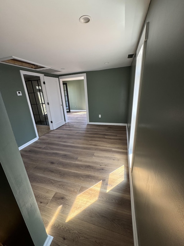 empty room with baseboards and wood finished floors