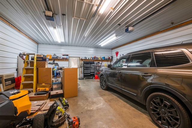 garage featuring a garage door opener and wooden walls