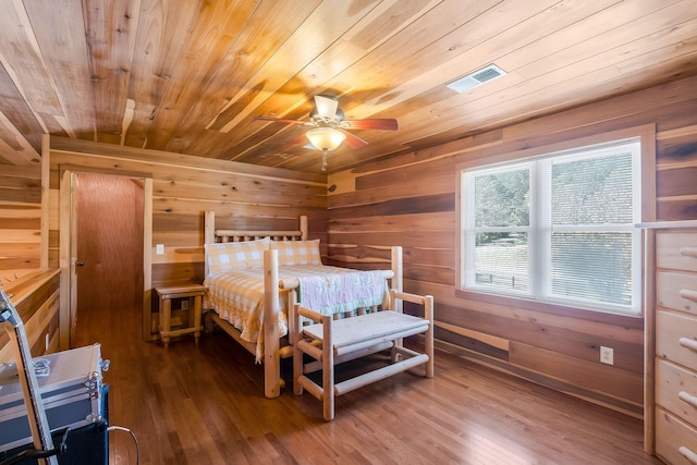 bedroom with wood walls, ceiling fan, wood ceiling, and hardwood / wood-style flooring