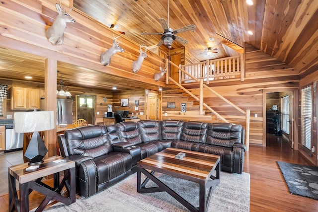 living room with ceiling fan, wooden ceiling, light hardwood / wood-style flooring, lofted ceiling, and wooden walls