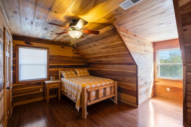 bedroom featuring ceiling fan, wood-type flooring, vaulted ceiling, wooden walls, and wood ceiling