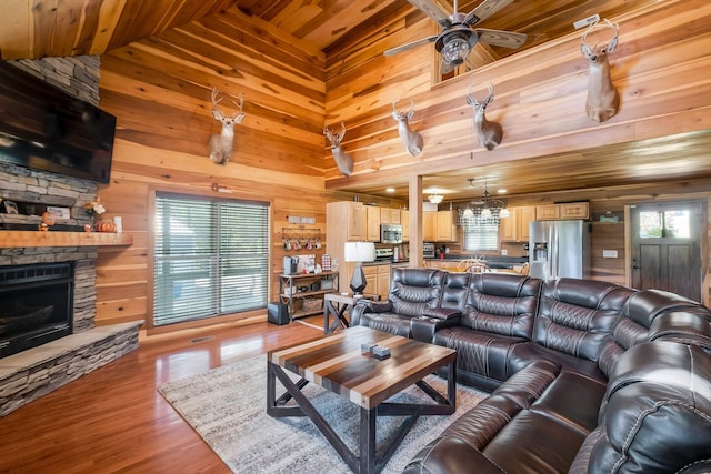 living room with a fireplace, ceiling fan, plenty of natural light, and wooden ceiling