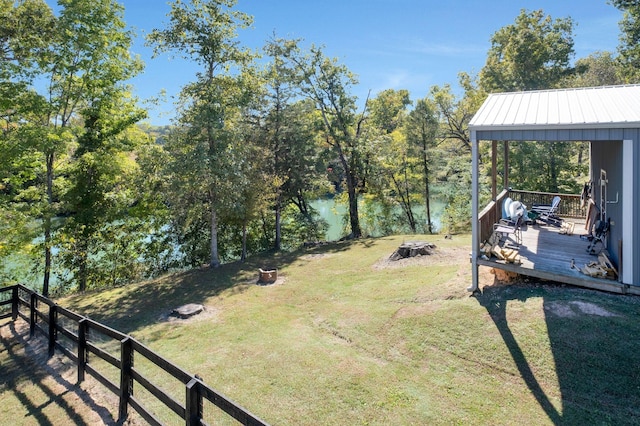 view of yard with a fire pit and a deck with water view