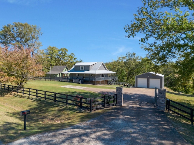 view of front of home with a front lawn, a rural view, an outdoor structure, and a garage