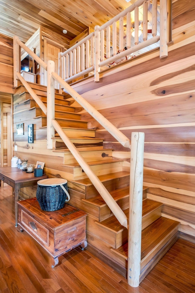 staircase featuring wood ceiling and hardwood / wood-style flooring