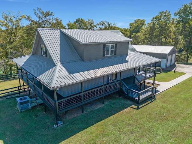 back of property featuring a lawn, central AC, a garage, an outbuilding, and a porch